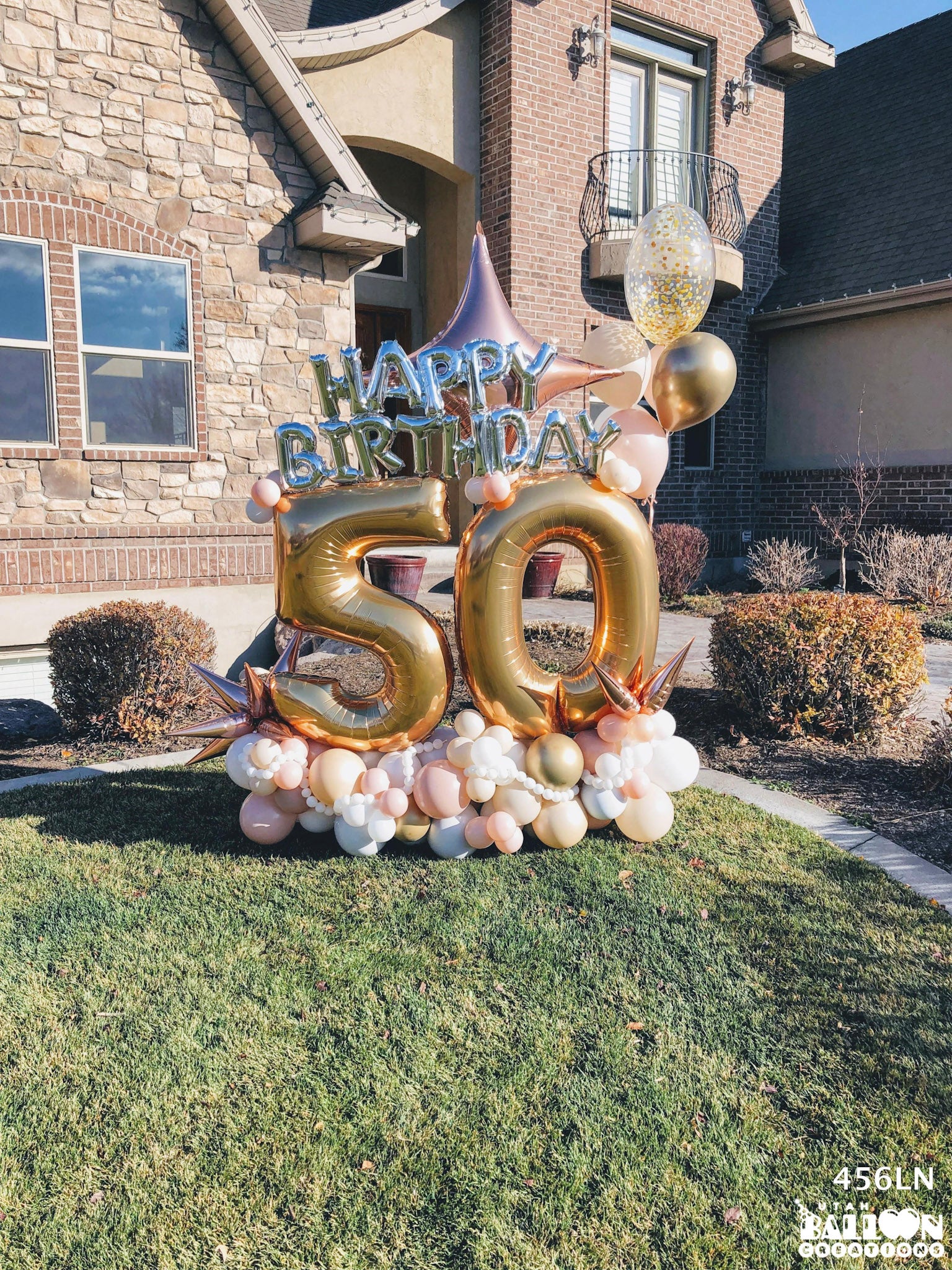 Gold "50" balloon in the front yard of a home in Highland, Utah. Balloon Birthday Yard Display features silver, gold, pink, blush, and rose gold balloons