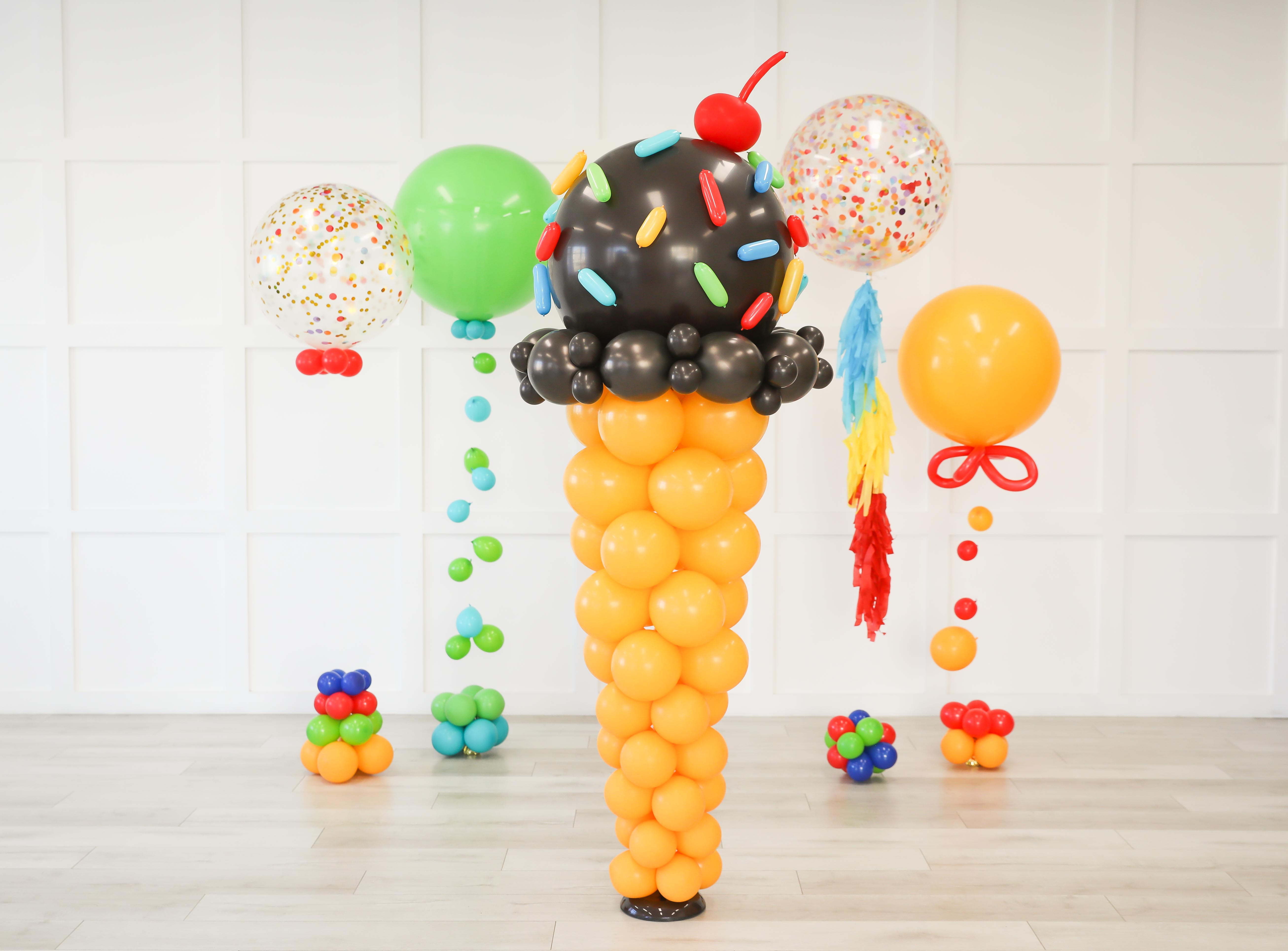 chocolate ice cream balloon column sits center among other colorful helium balloons celebrating a summer carnival vibe