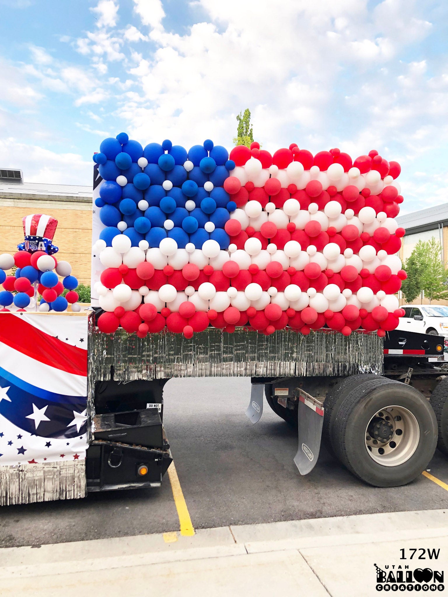 Truck bed decorated with an American flag made of balloons on a clear day for 4th of July Parade in Provo Utah