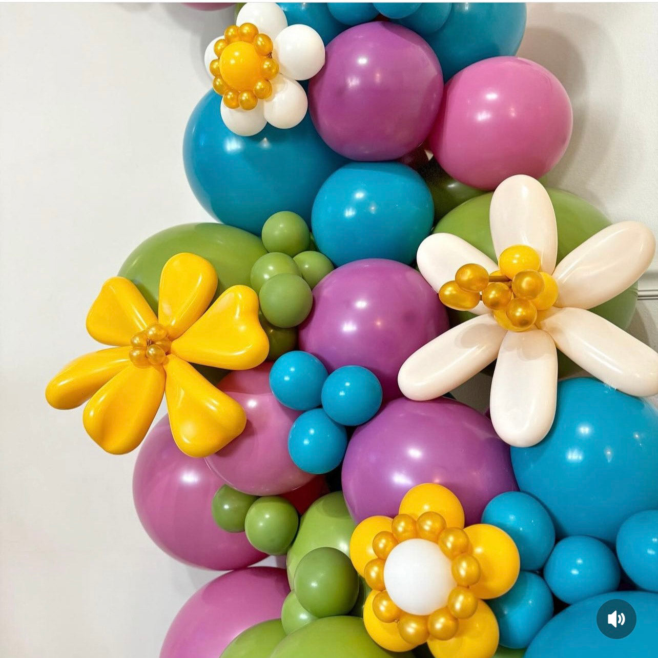 Colorful balloon arrangement with flower shapes on a white background