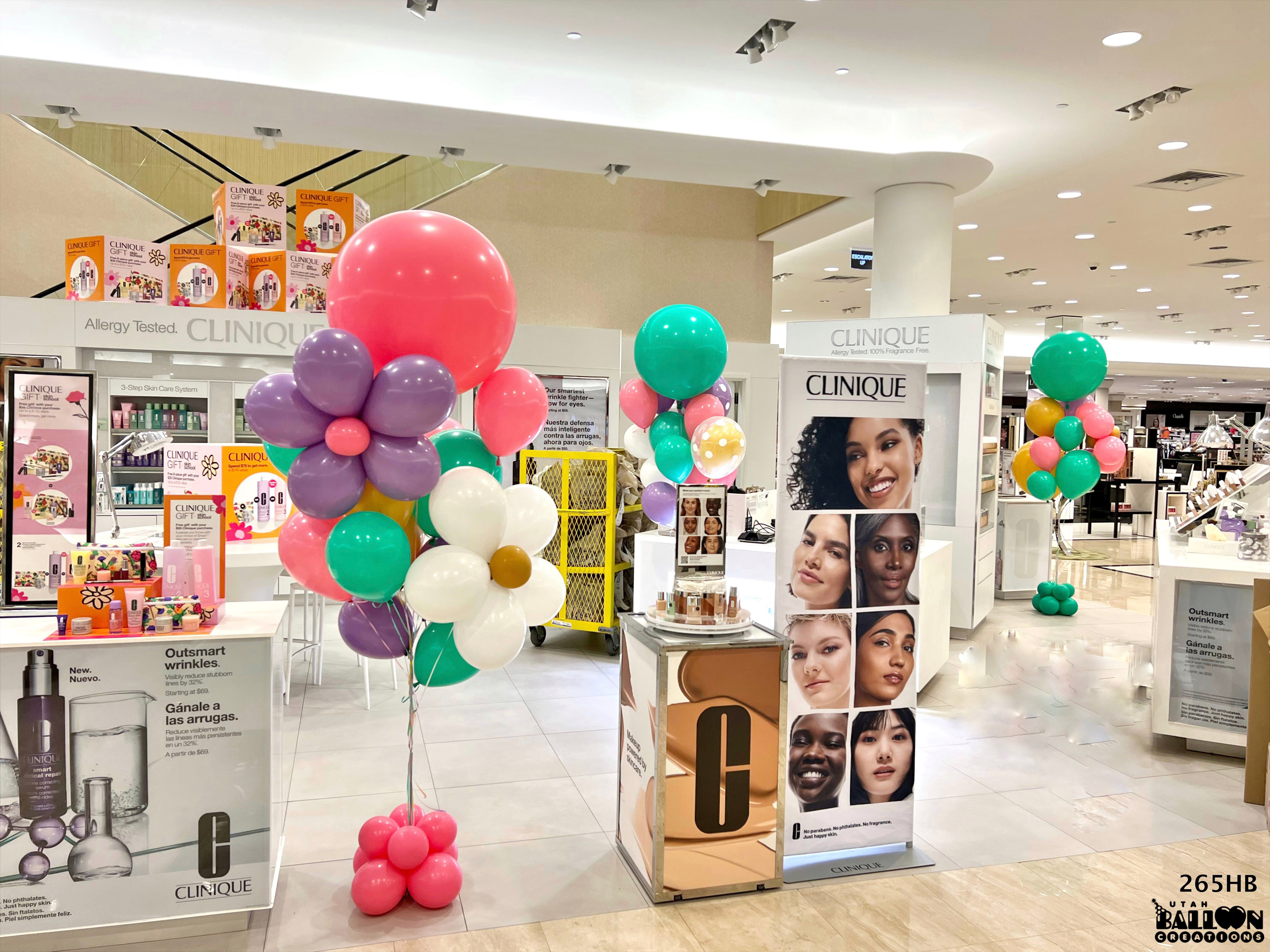 Clinique display with colorful balloons and promotional materials in a store setting