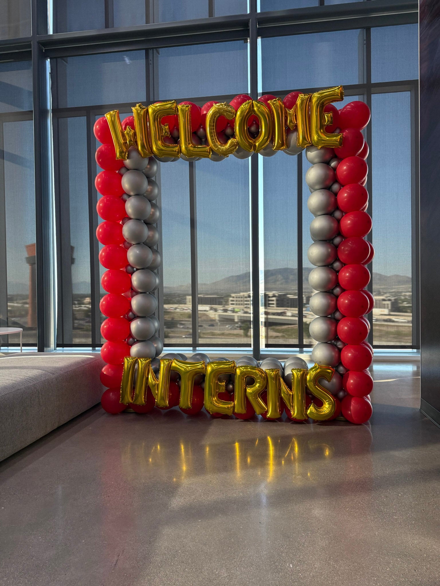 Balloon frame with 'Welcome Interns' text in a modern indoor setting for photo op at Adobe