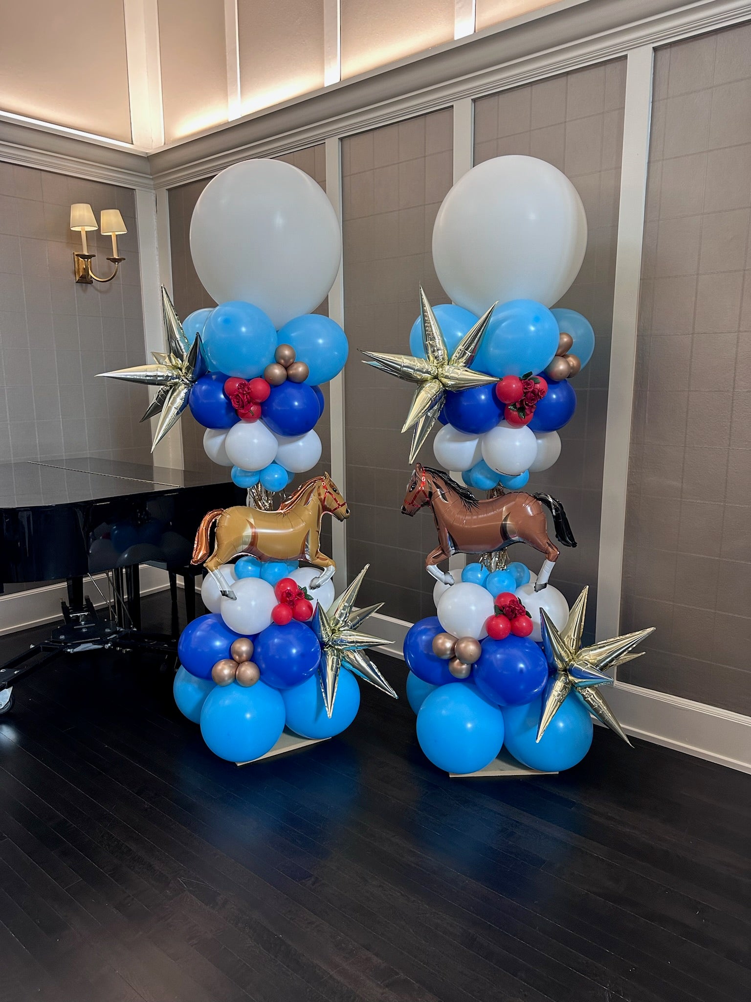 Balloon decorations with horses and stars on a table in a room.