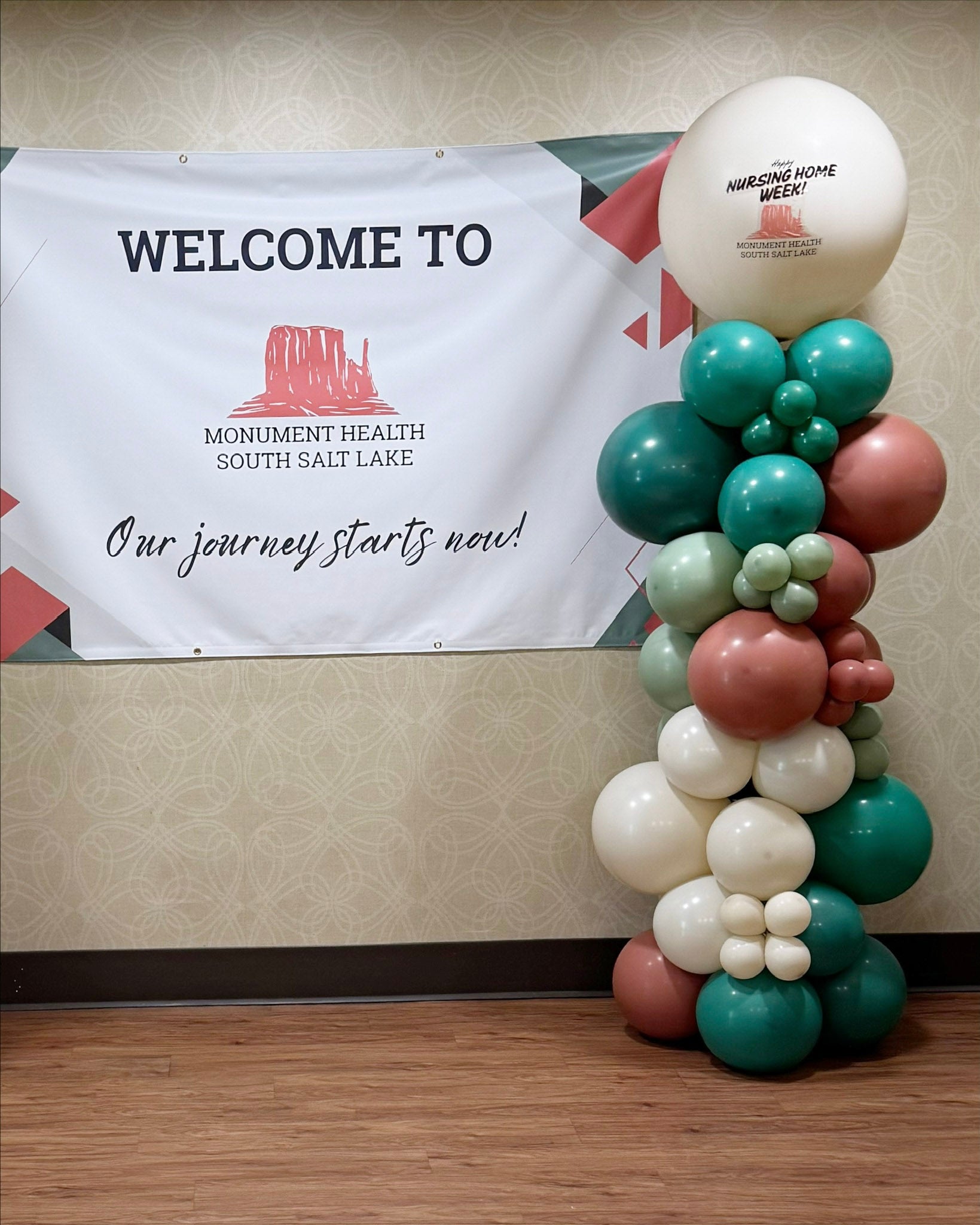 Balloon arch in front of a 'Welcome to Monument Health South Salt Lake' banner.