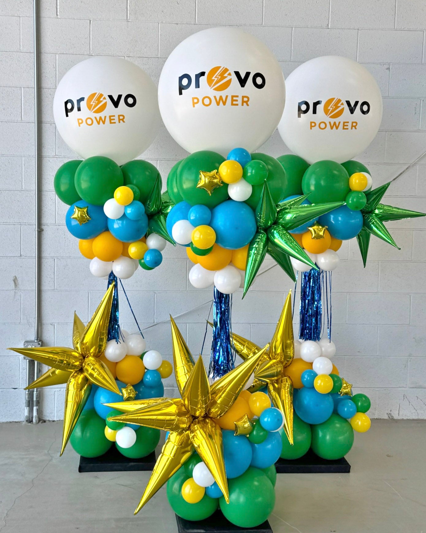 Decorative balloon display with 'Provo Power' balloons against a tiled wall.
