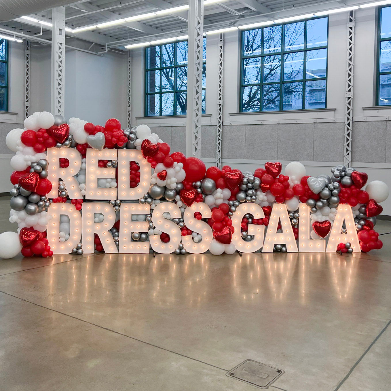 red, white, silver balloons fully encompass  the phrase "Red Dress Gala" AlphaLit SLC Light up Marquee letters