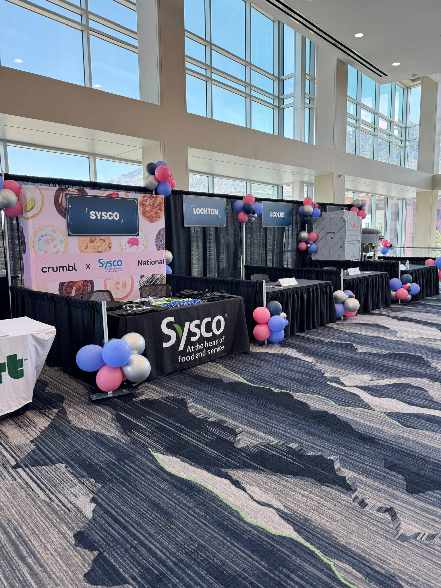 Colorful balloon accent pops accentuate vendor booths at Crumbl conference